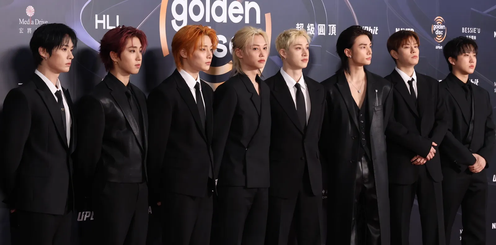 Os integrantes do Stray Kids de terno preto em um tapete vermelho